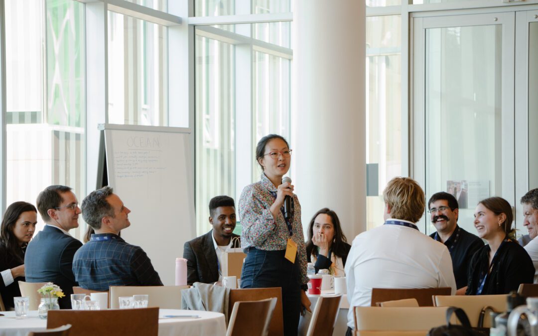 Participants attend a Carbon Removal Workshop. A woman stands up to speak.