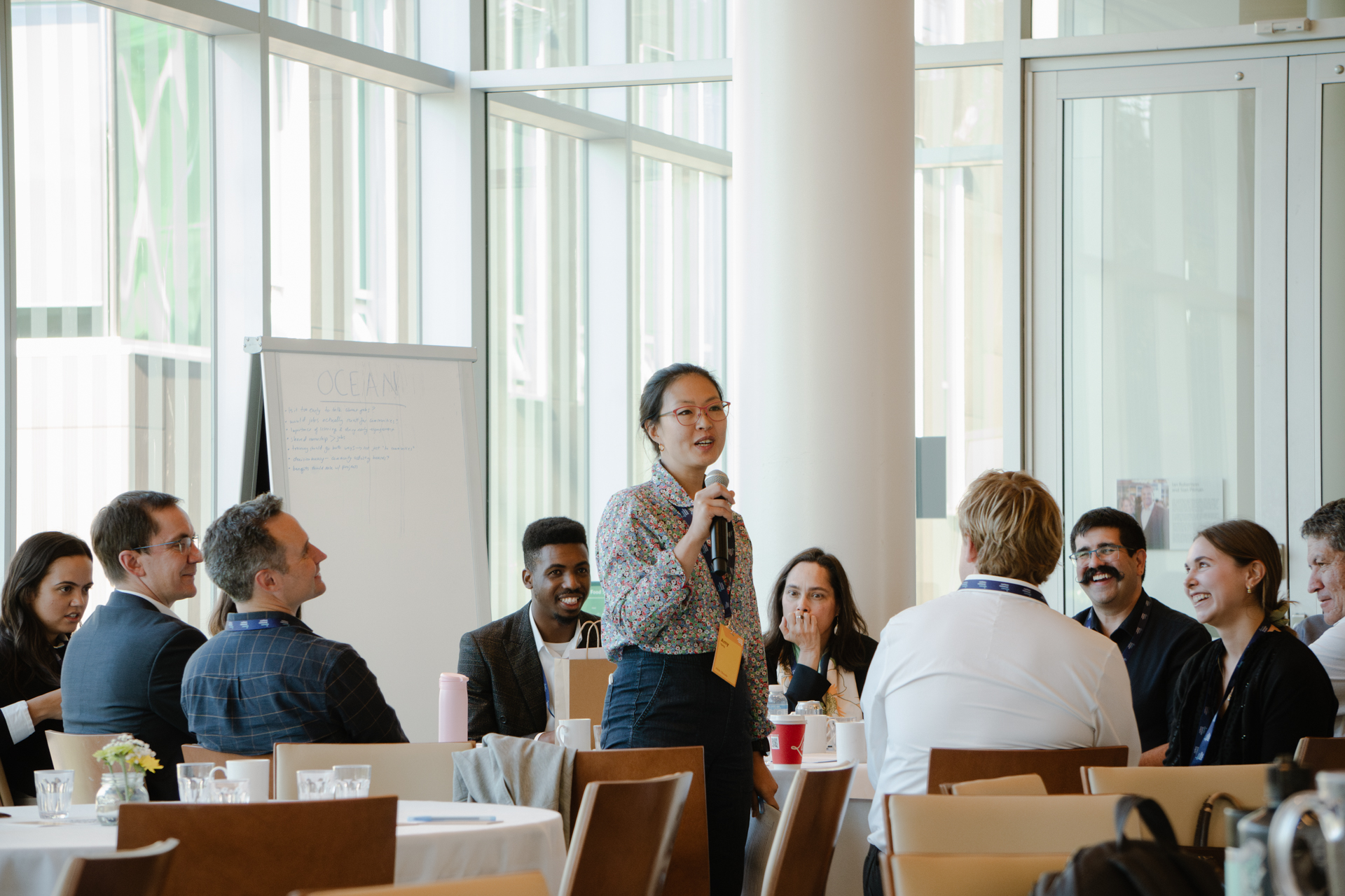 Participants attend a Carbon Removal Workshop. A woman stands up to speak.